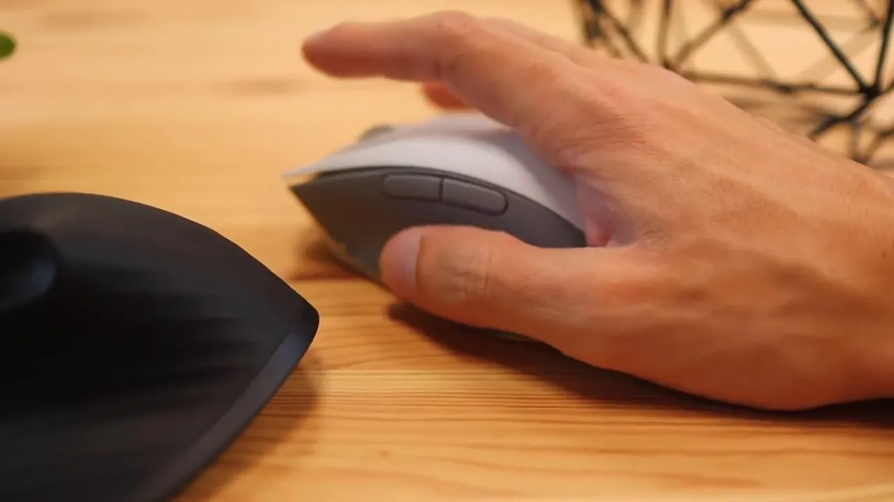 Hand resting on the side of the Razer Pro Click mouse next to a black mouse