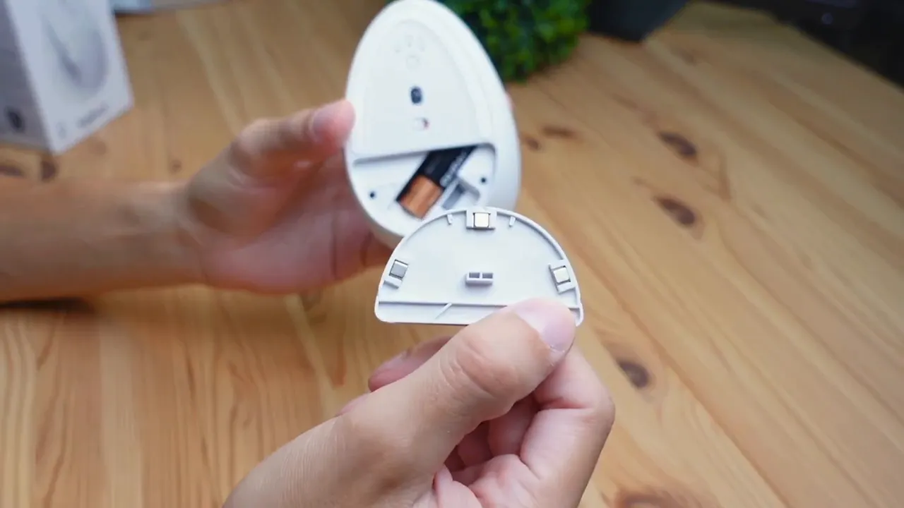 Battery compartment opened revealing AA battery and magnetic lid