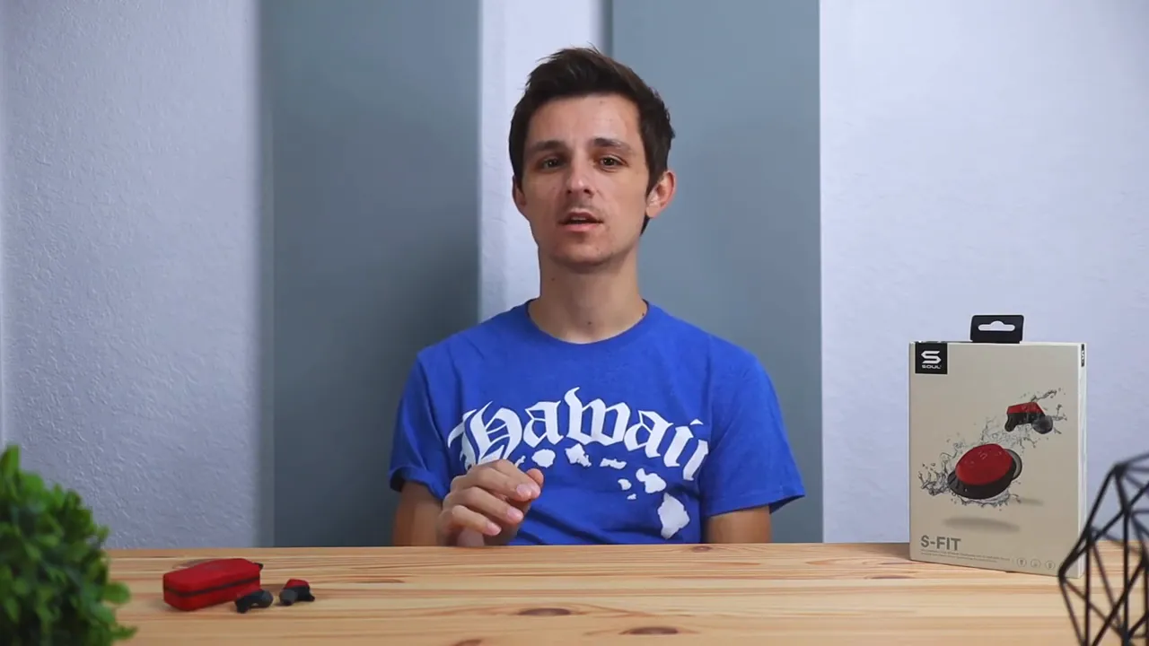 Presenter with Soul S-FIT retail box on table while explaining bass-forward sound