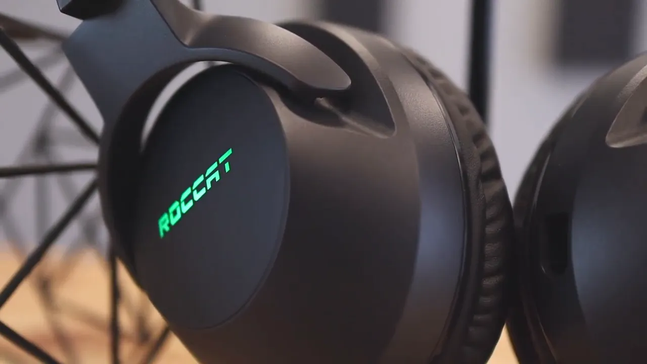 Close-up of headset earcup with illuminated Roccat logo in cyan