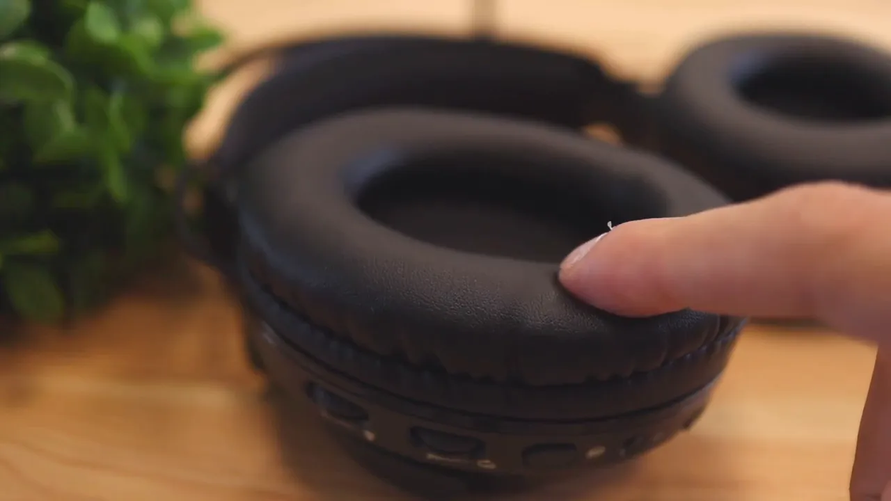 Finger pressing into the soft ear cushion on the headset