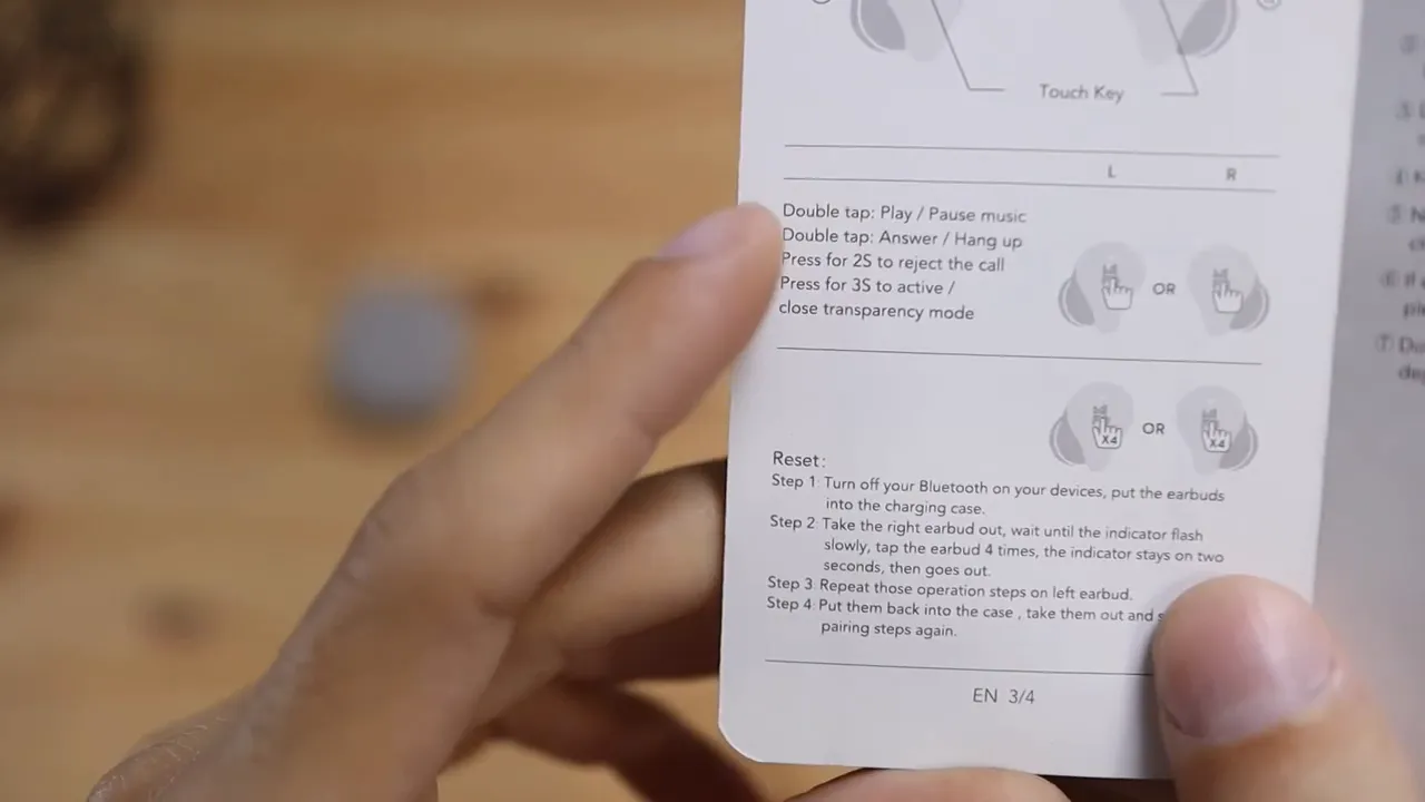 Close-up of the instruction manual showing touch control diagrams for the earbuds