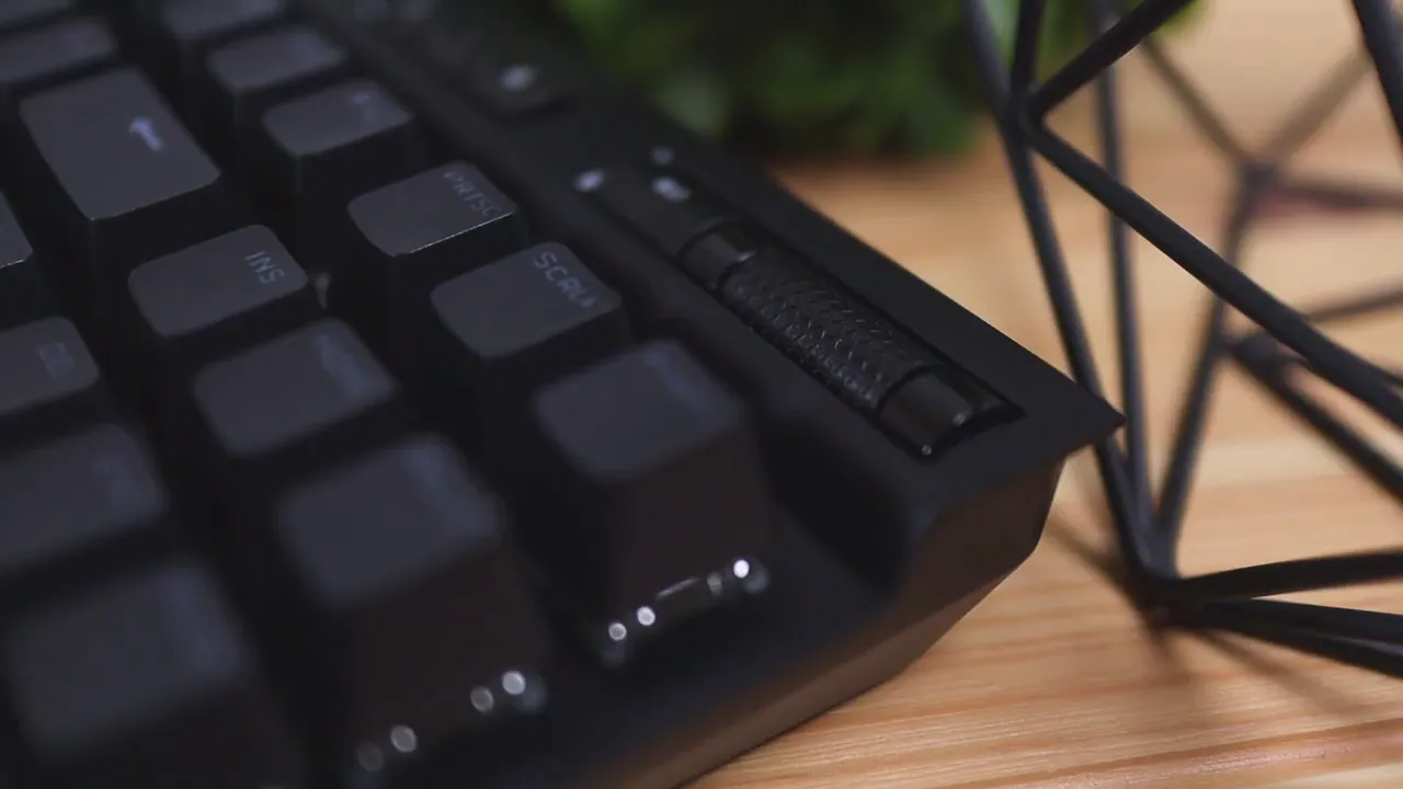 Side view of Corsair K70 TKL showing low-profile edge, keycaps and volume roller with desk surface