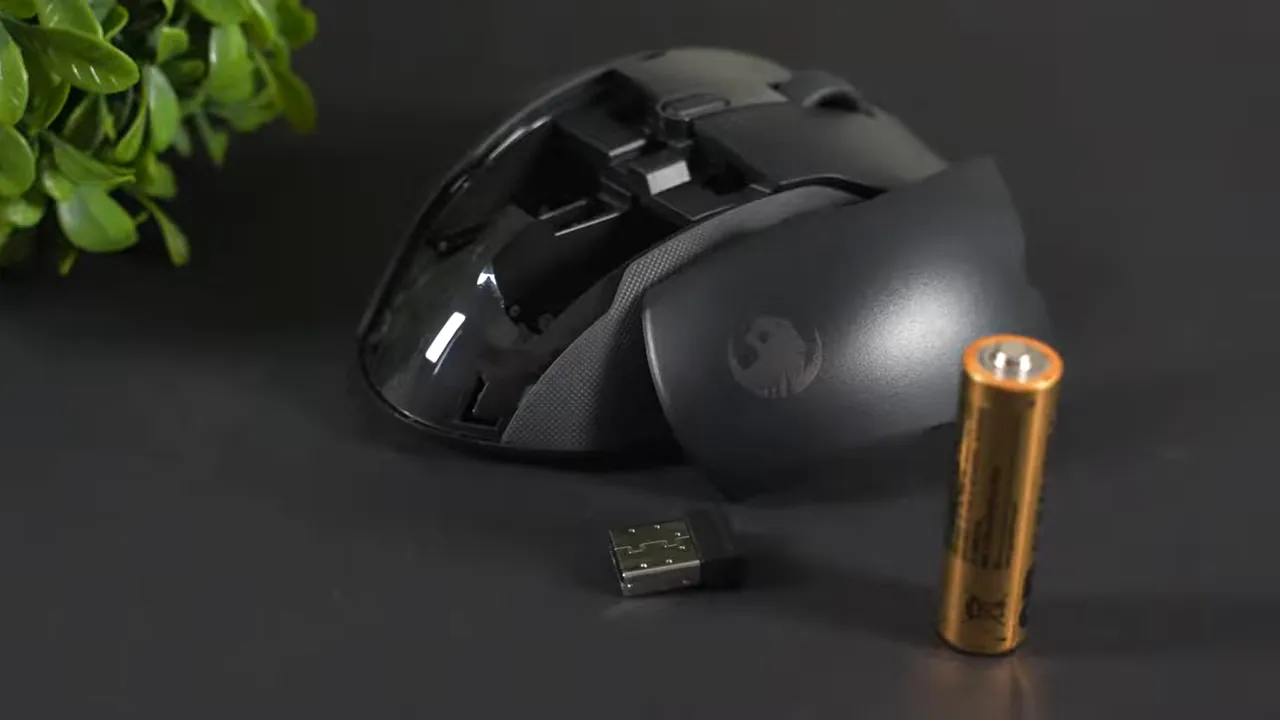 AA battery and USB receiver next to Roccat Kone Air with removed backplate