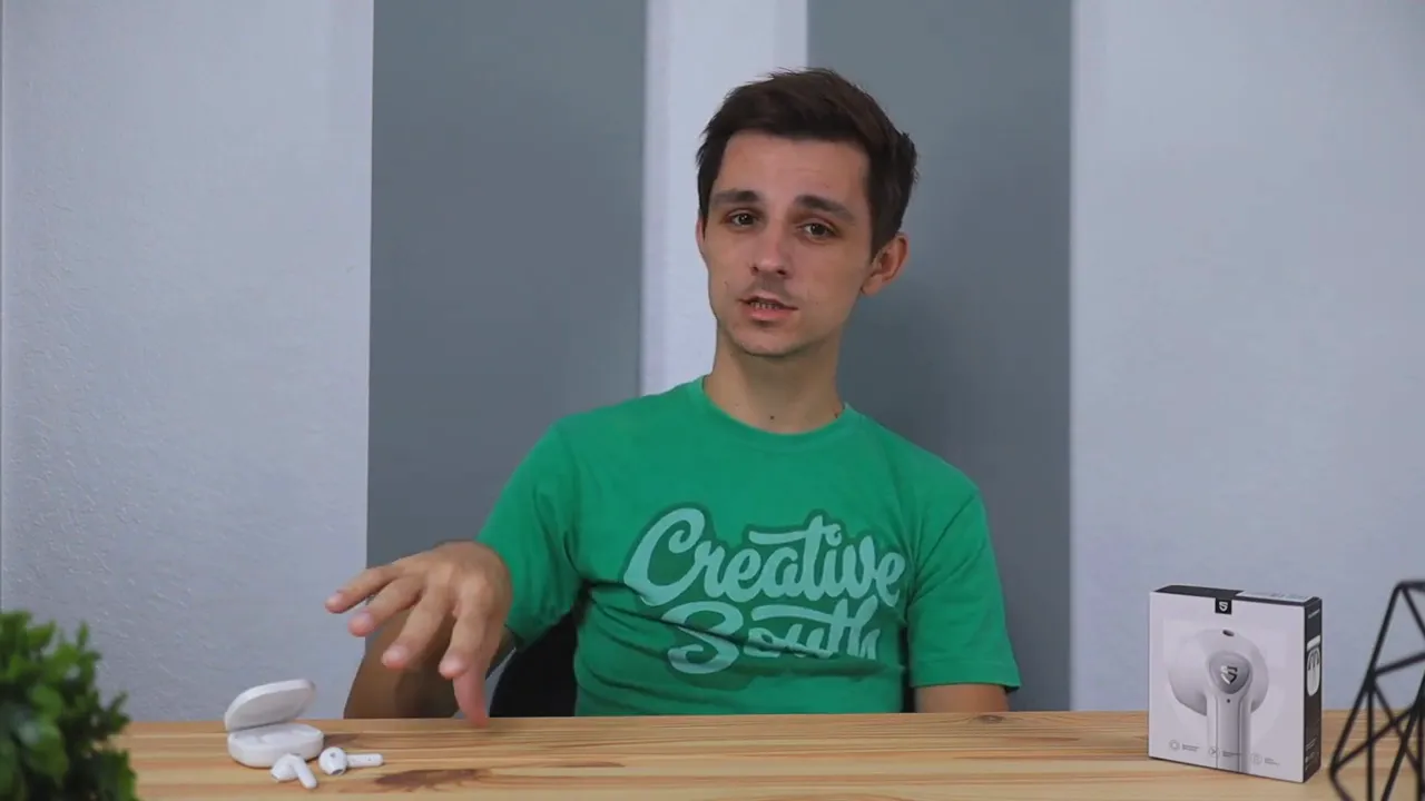 Person presenting SoundPEATS TrueAir 2 microphone results with earbuds and product box in background