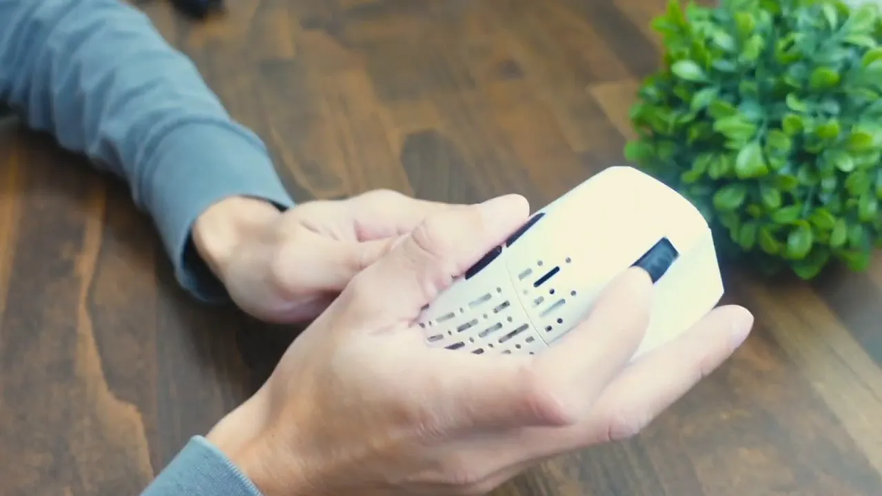 Hands holding Projects Gaming Sleeper showing rubber scroll wheel, primary clicks and honeycomb shell