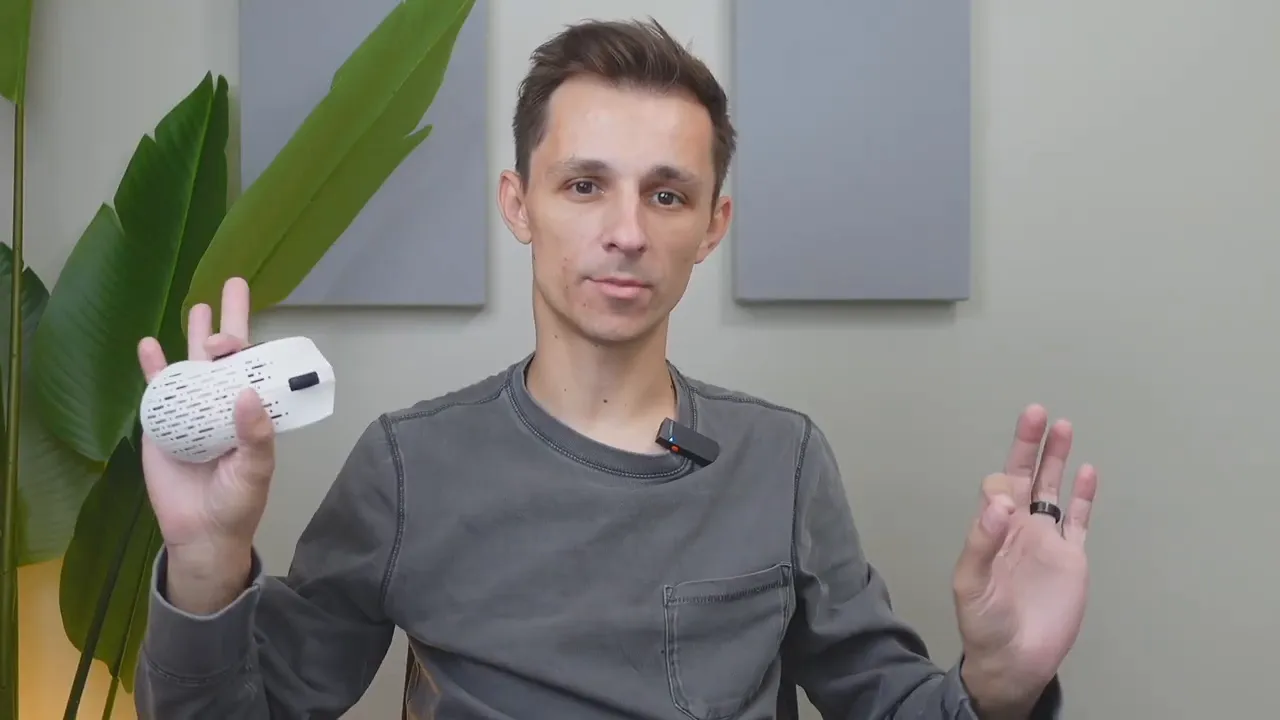 Reviewer holding the Projects Gaming Sleeper with the USB‑A wireless dongle visible