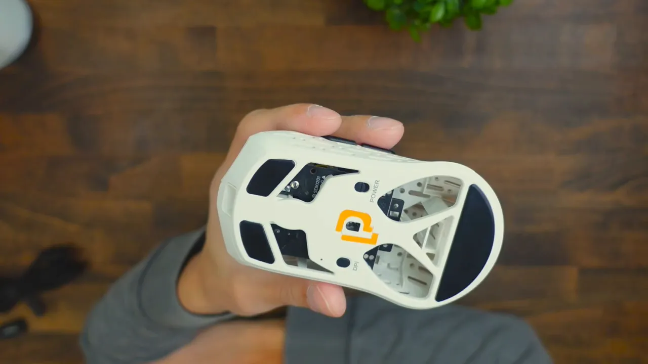 Top-down clear view of Projects Gaming Sleeper mouse underside showing optical sensor, DPI and power buttons