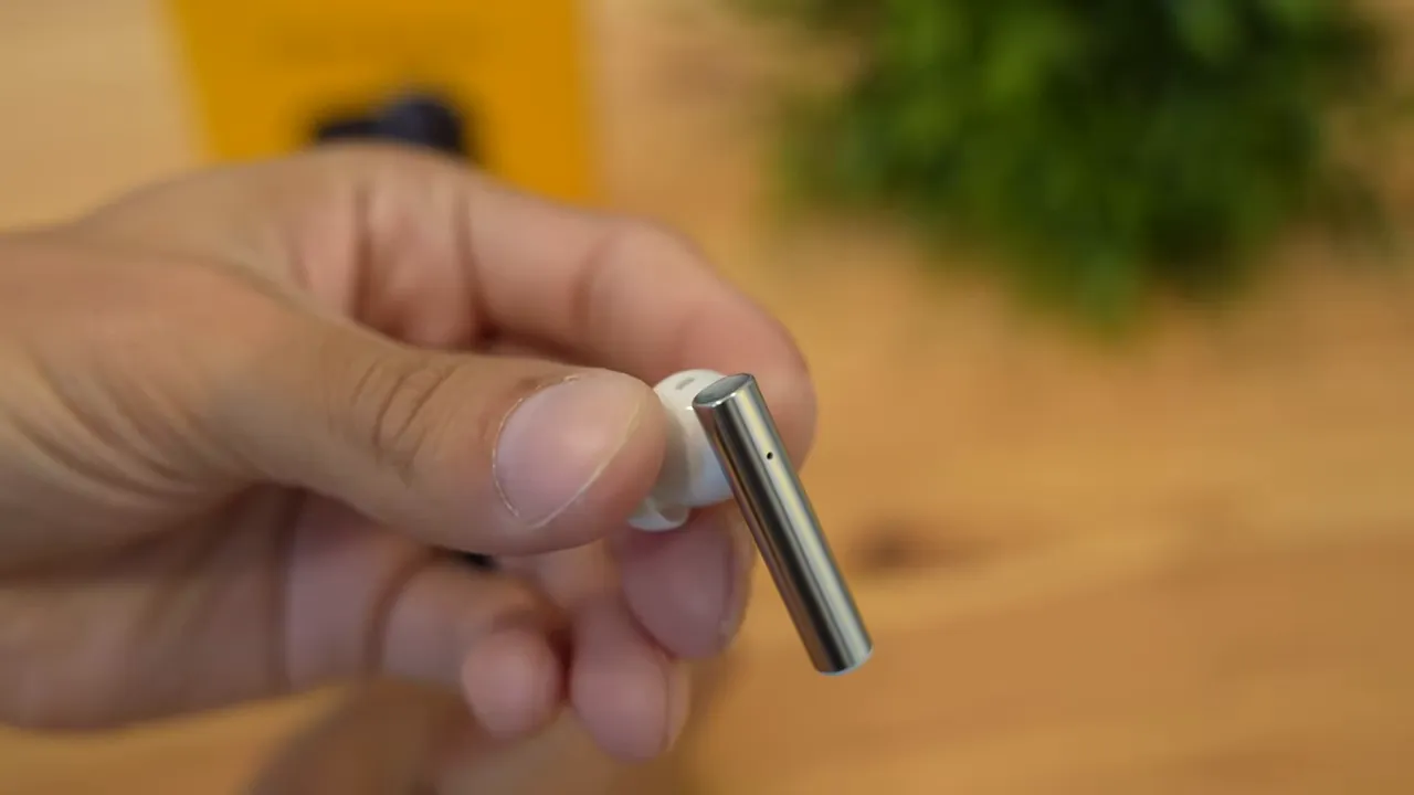 Close-up of Realme Buds Air 2 earbud showing metallic cylindrical stem and silicone tip