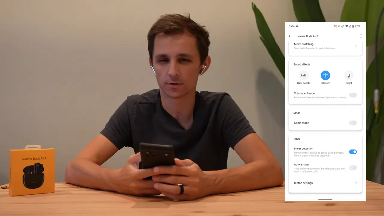 Presenter at table with Realme Link app overlay visible on the right showing sound effects and the Game mode setting