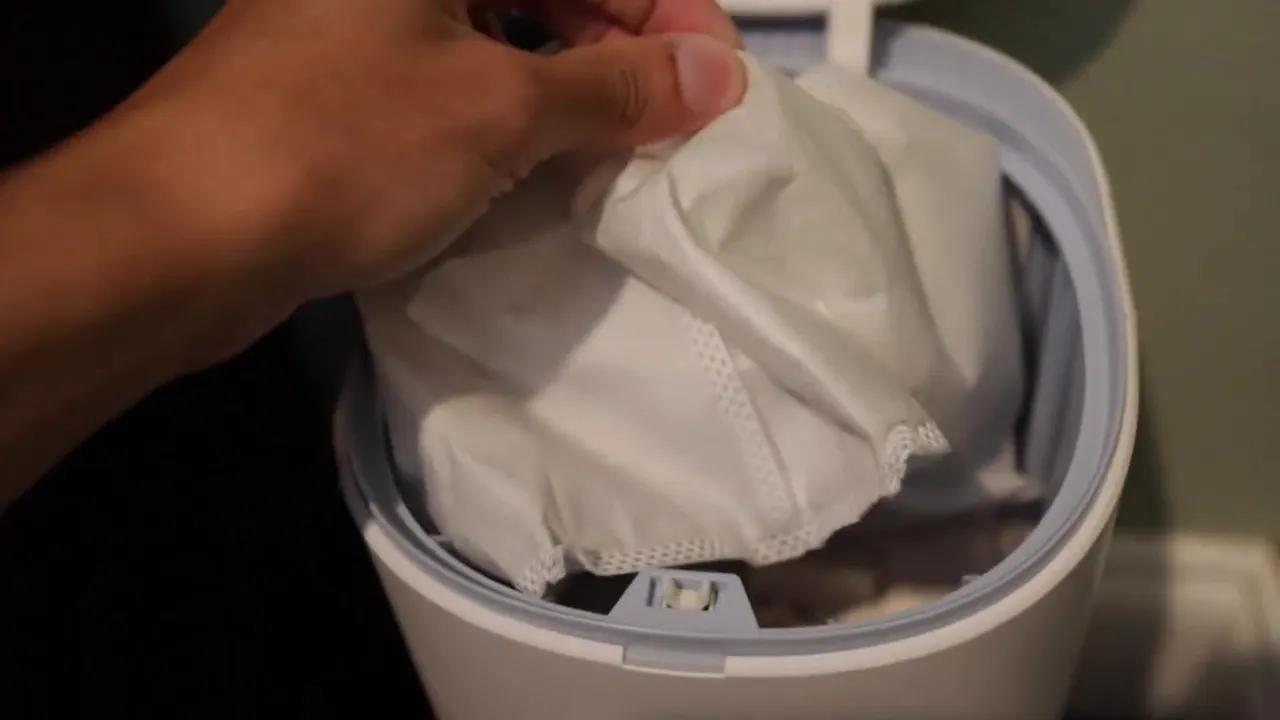 Hand removing replaceable dirt bag from Yeedi auto-empty dock