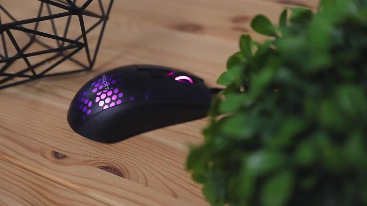 Close-up of Roccat Burst Pro mouse side profile with RGB lighting on a wooden desk