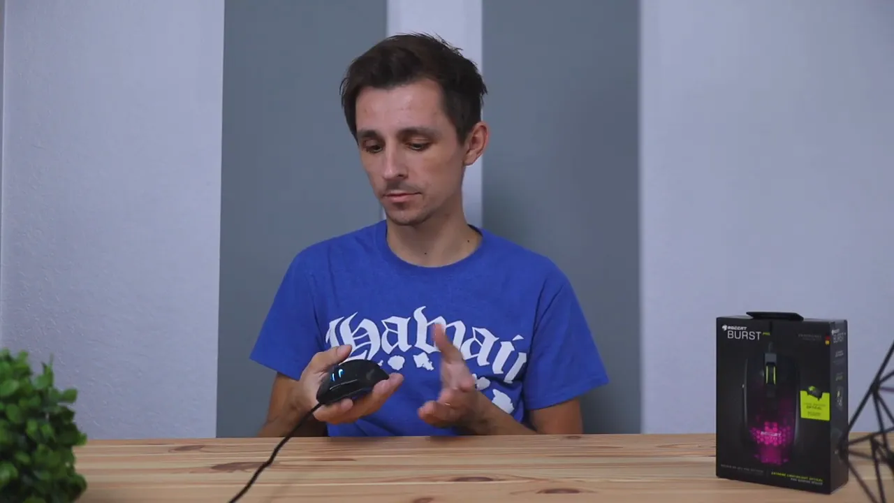 Roccat Burst Pro gaming mouse shown in hand with product box in background