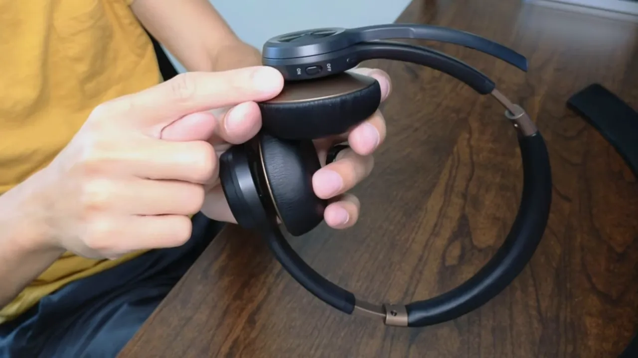 Close-up of NUROUM HP30 earcup showing the on/off switch and adjacent control buttons.