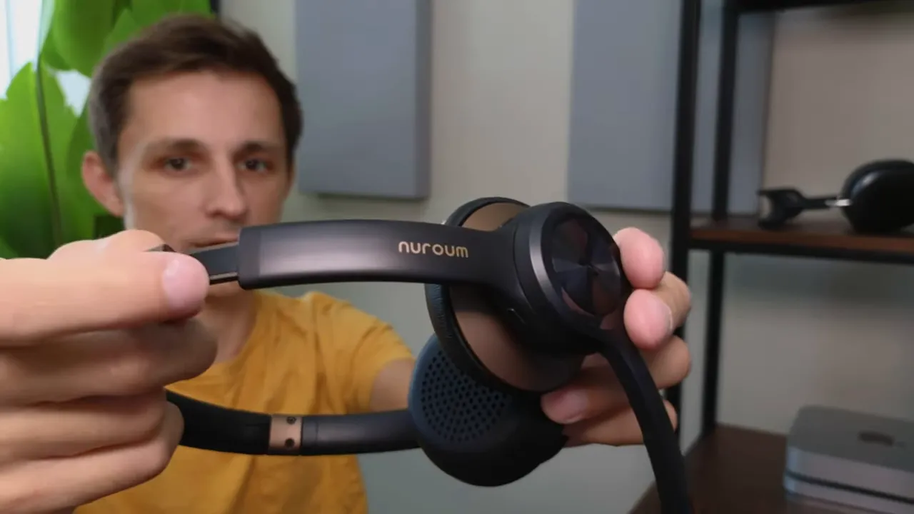 Close-up of hands adjusting the HP30 sliding headband, NUROUM logo visible