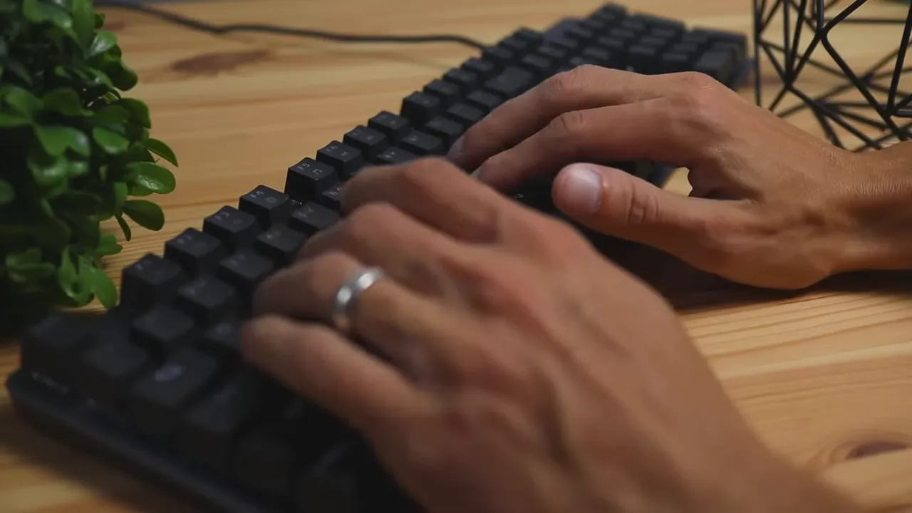 Hands typing on the Logitech K845 mechanical keyboard showing keycaps and typing posture