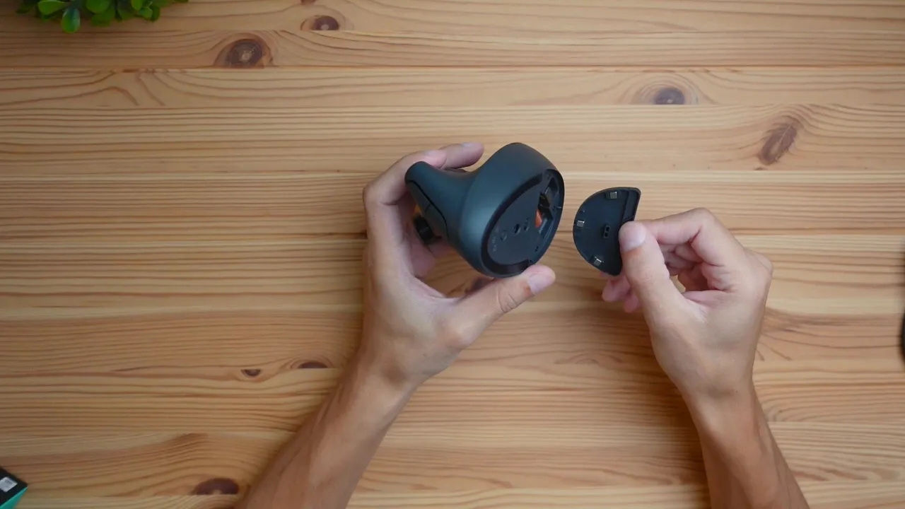 Battery compartment open showing AA battery and stored USB receiver