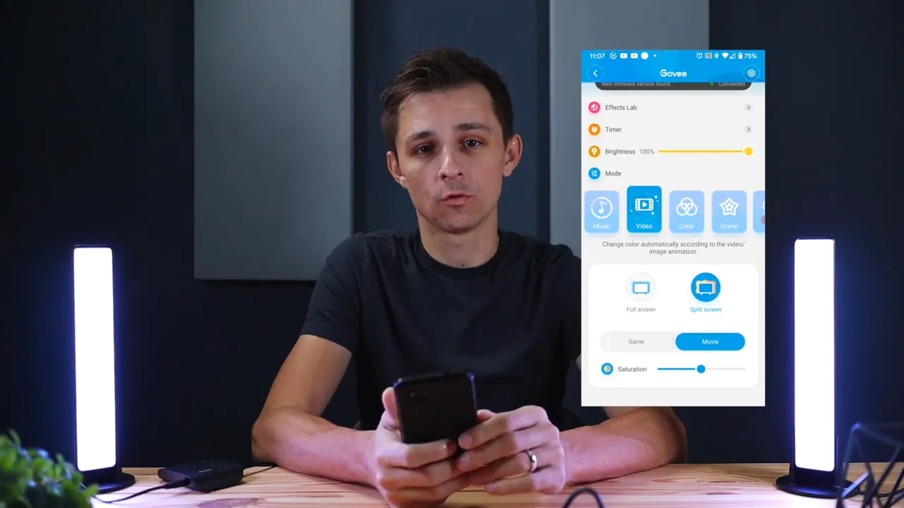 Govee app showing video mode overlay with bright LED light bars visible left and right of presenter