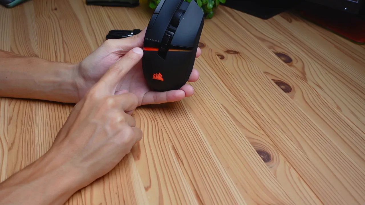 Mouse in a dark environment showing the 'saber' RGB effect and Corsair logo glow