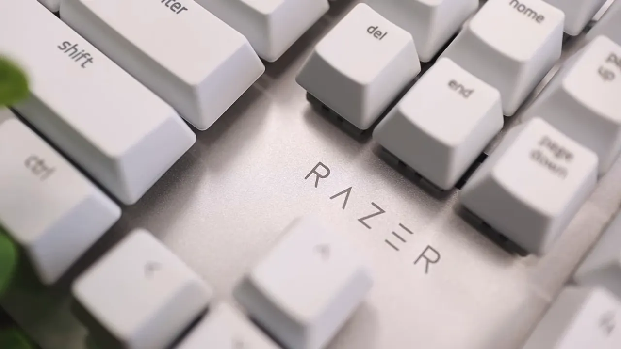 Close view of white keycaps over a silver top plate with the Razer logo printed between keys
