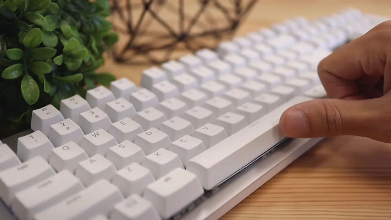 Finger pressing the left side of the white space bar on the keyboard
