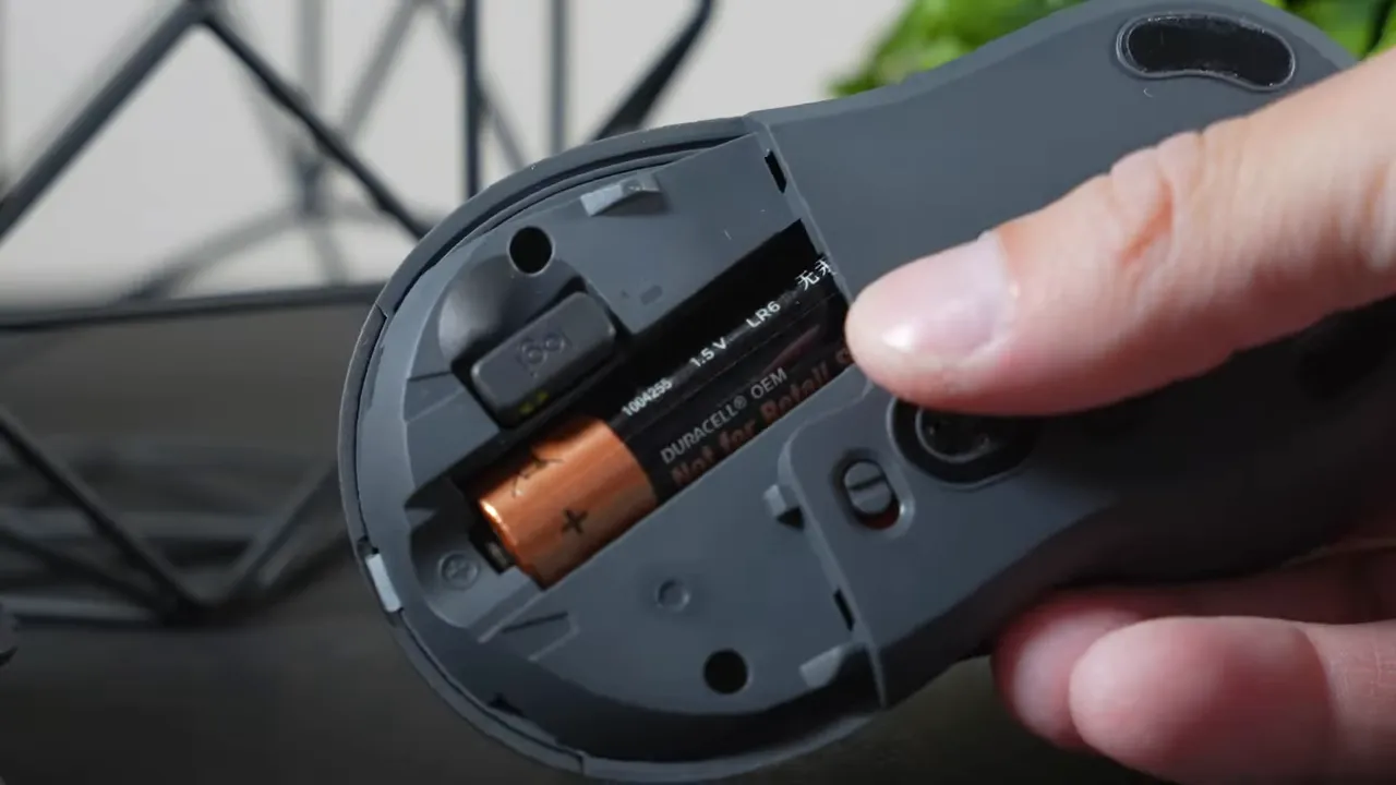 Open battery compartment of Logitech M550 with one AA battery and slot for USB receiver