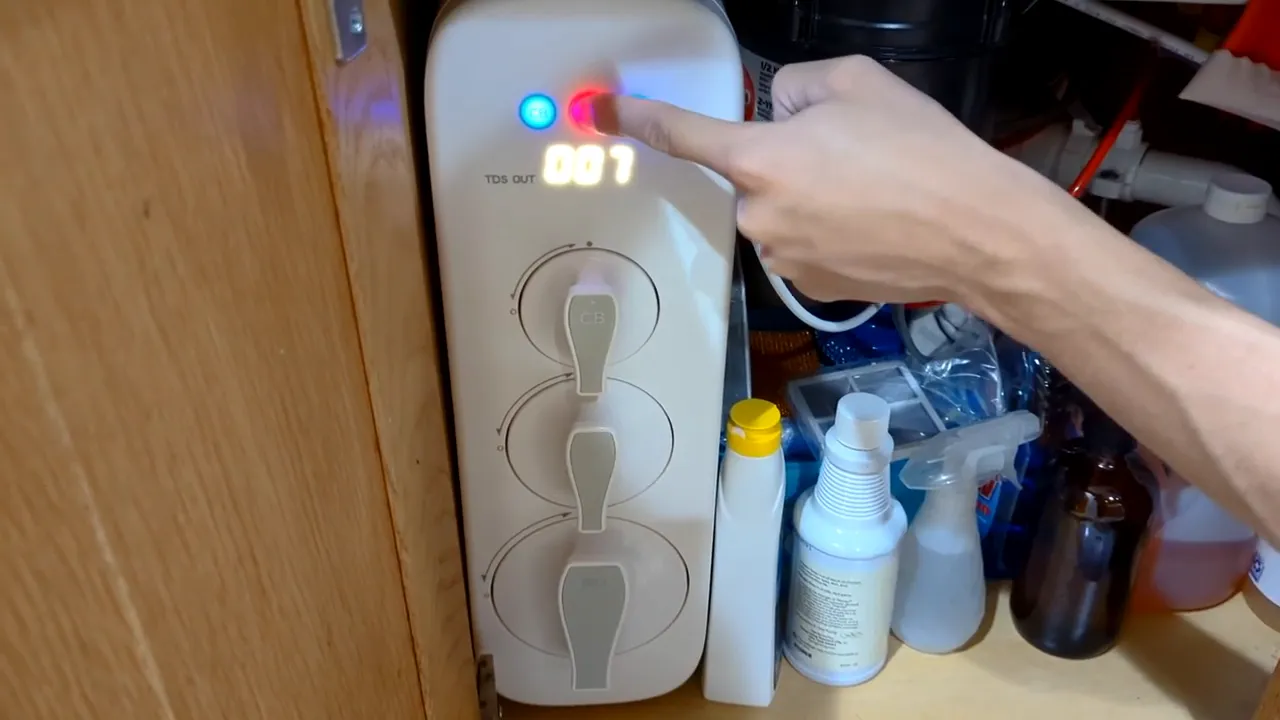 Finger pressing the center red CF status LED on a Waterdrop G3 reverse osmosis unit