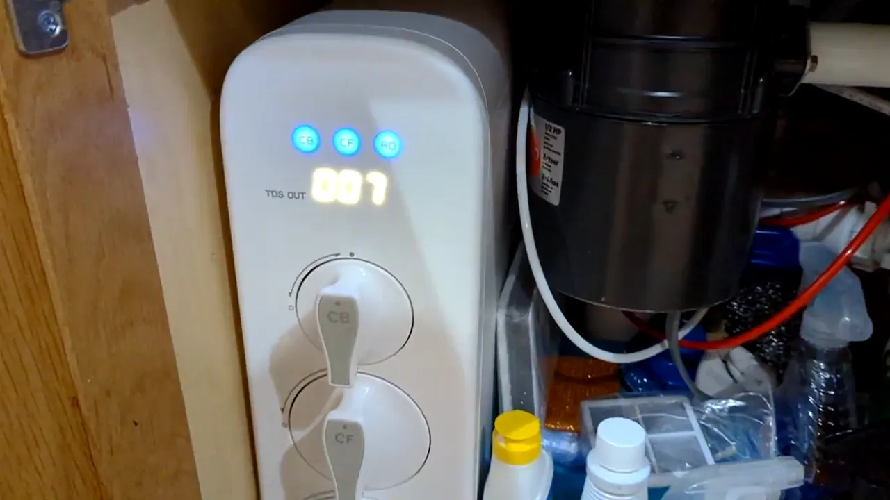 Waterdrop G3 unit inside cabinet showing blue indicator lights and TDS display reading 007