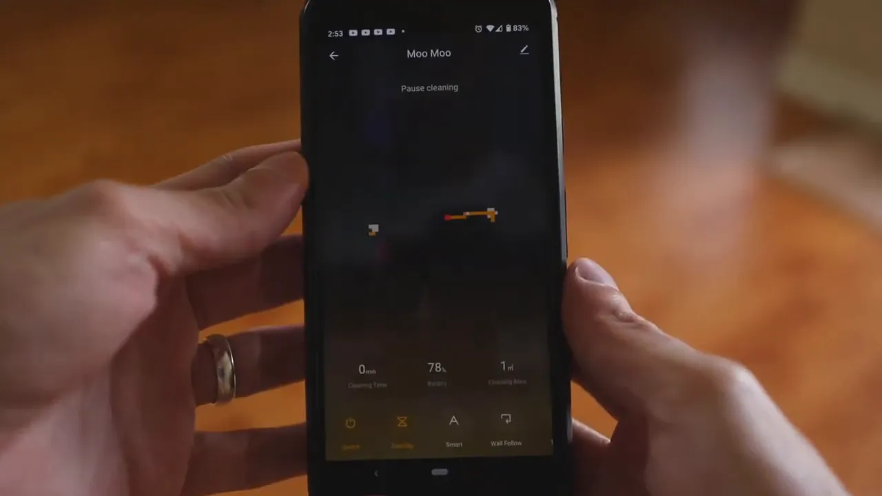Smartphone showing MooSoo app map, cleaning status and battery percentage