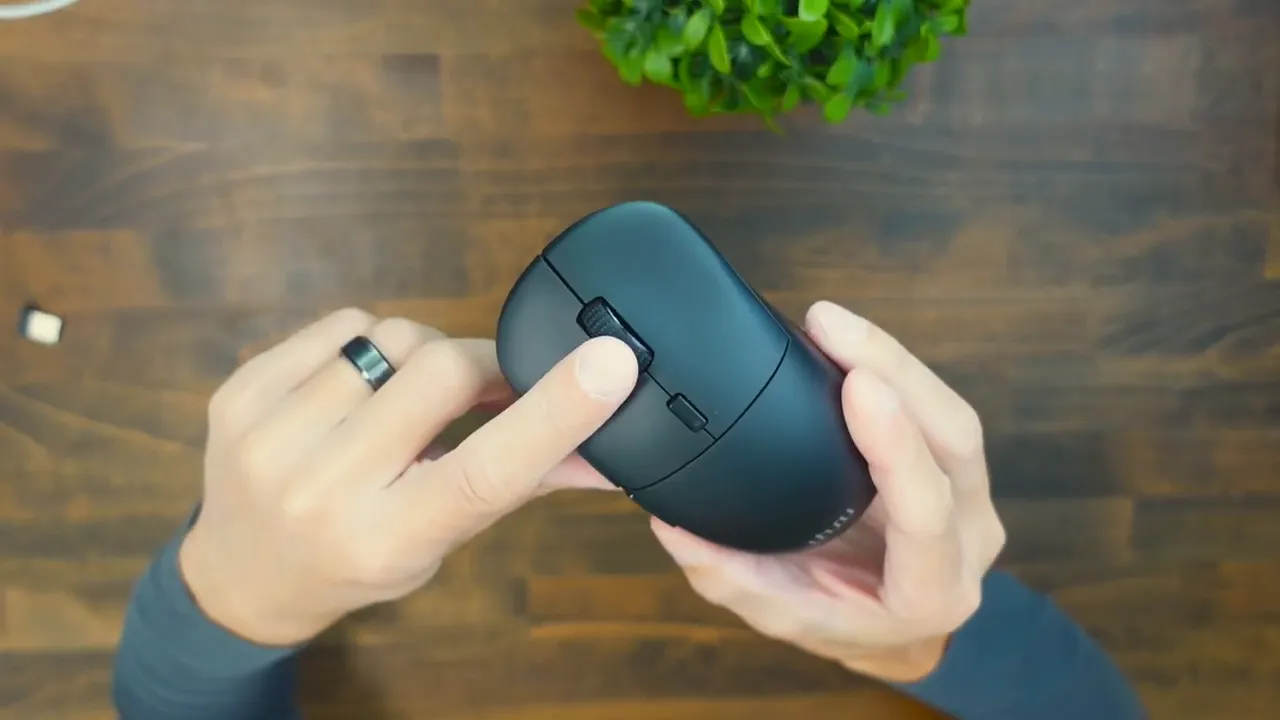 Uhuru WM-09 top view with rubberized scroll wheel and DPI button, held in hands