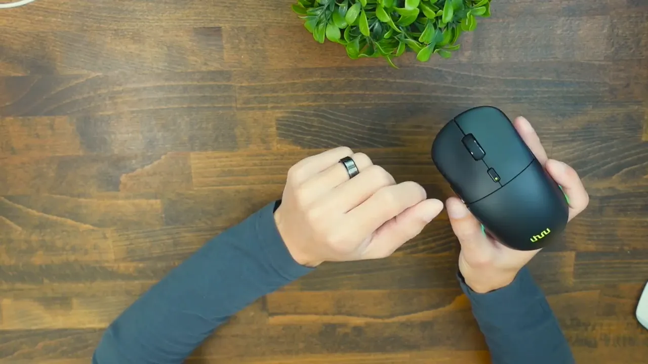 Top-down view of Uhuru WM-09 in hand showing scroll wheel, DPI/RGB button, and illuminated logo