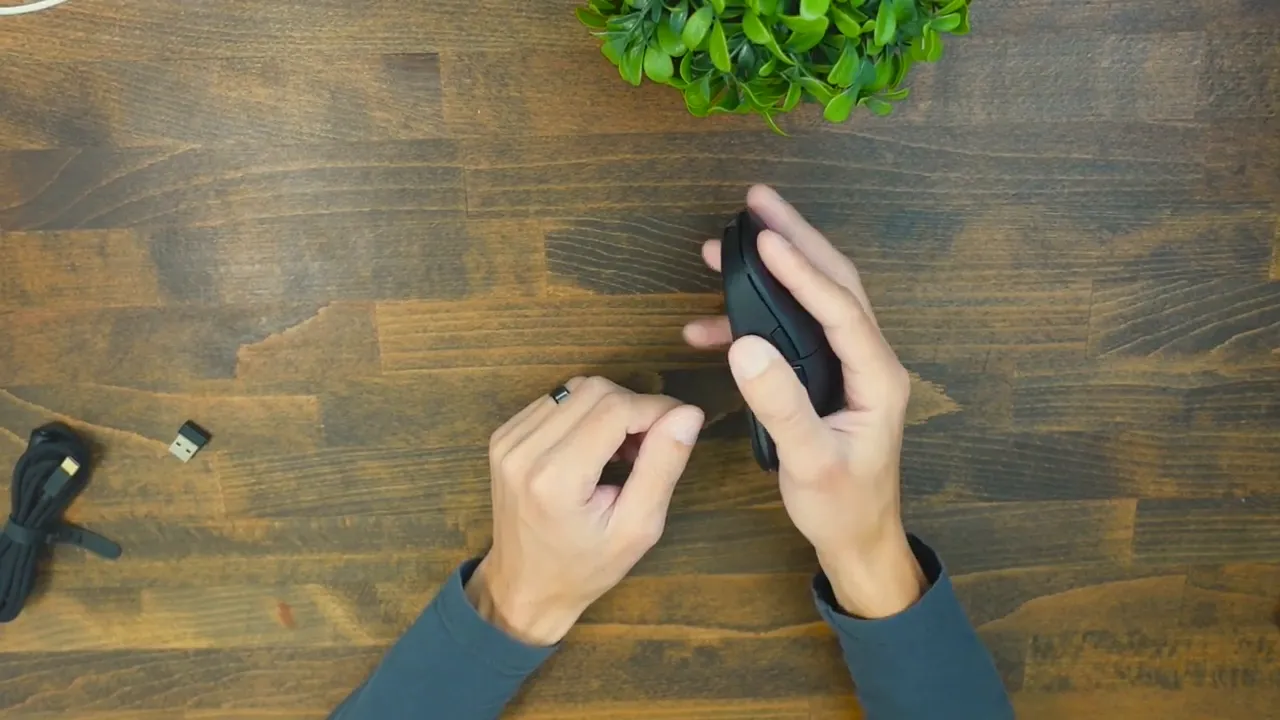 Top-down view of Uhuru WM-09 held in right hand showing thumb placement and overall fit for mid-sized hands