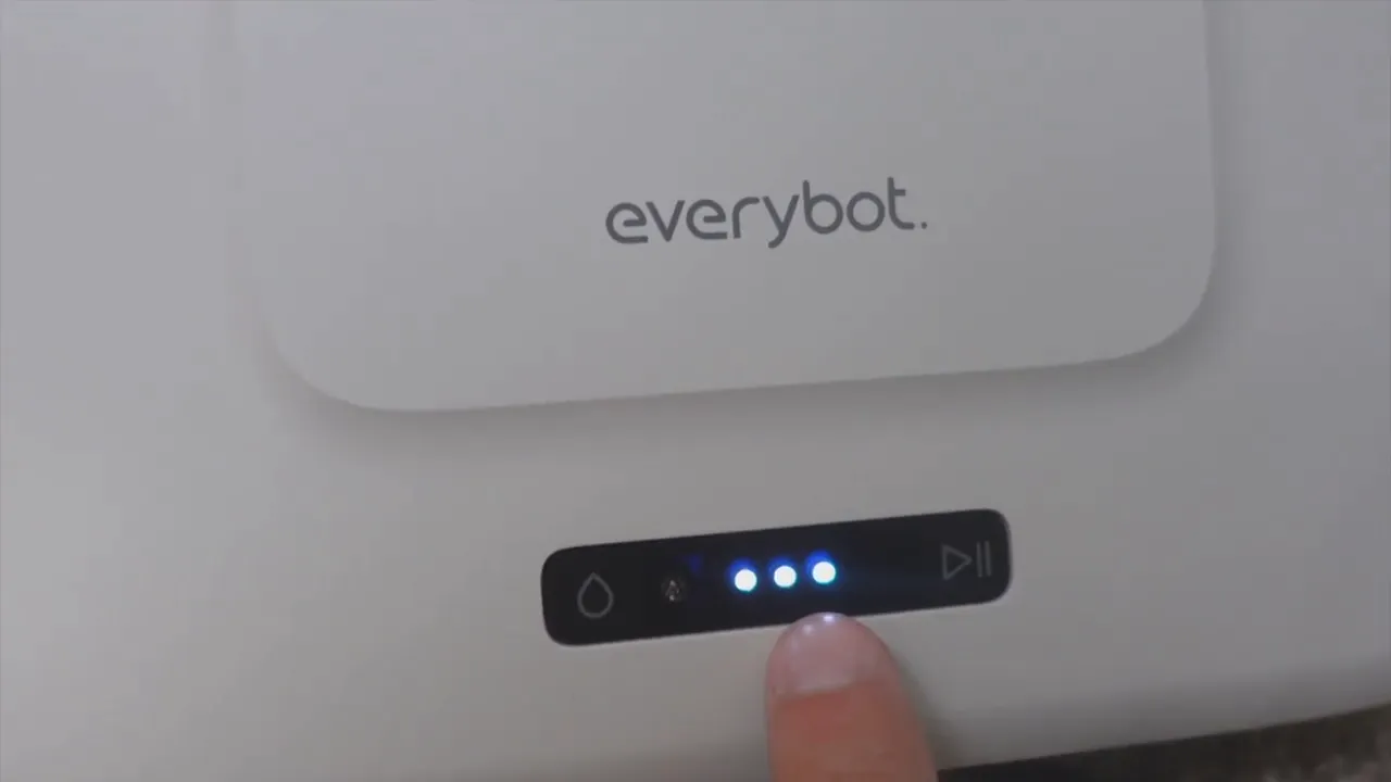 Finger pointing at the EVERYBOT Edge2 LED charge indicator showing three lit blue lights