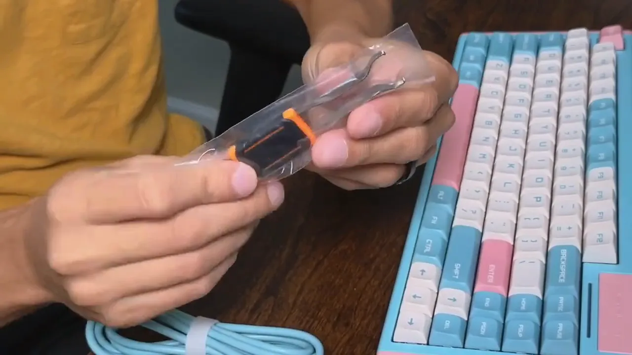 Keycap and switch puller in plastic packaging beside the DUSTSILVER D84 keyboard and coiled USB-C cable
