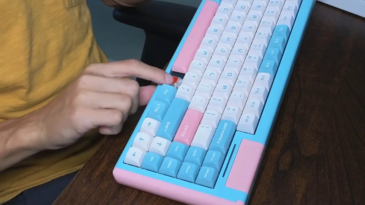 Finger pointing at an exposed hot-swappable mechanical switch on the DUSTSILVER D84 keyboard