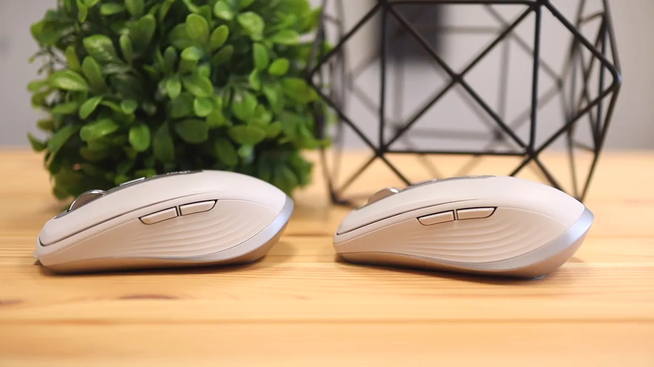 Side view of two light colored Logitech MX Anywhere mice on a wooden desk