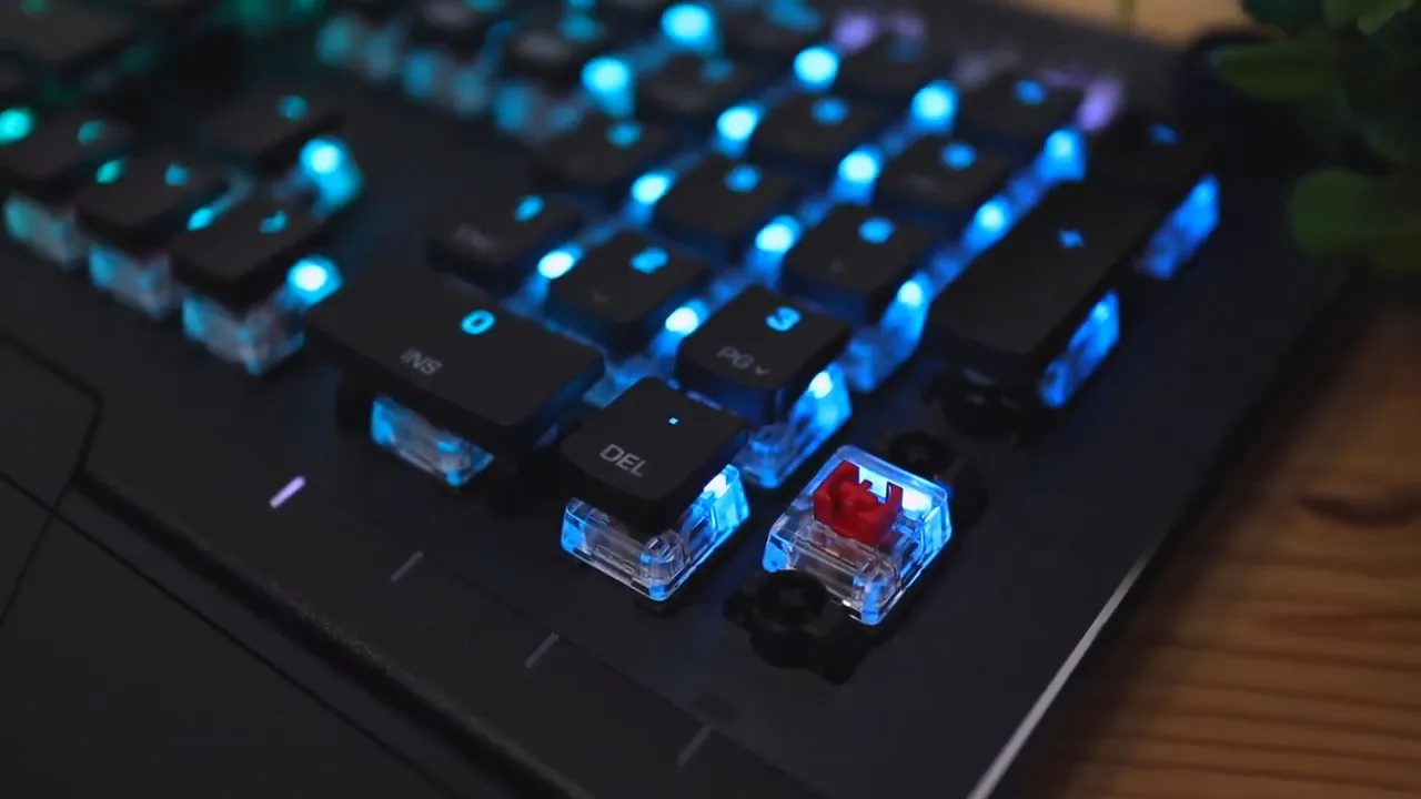 Close view of exposed transparent switch housings and illuminated keycaps on the keyboard
