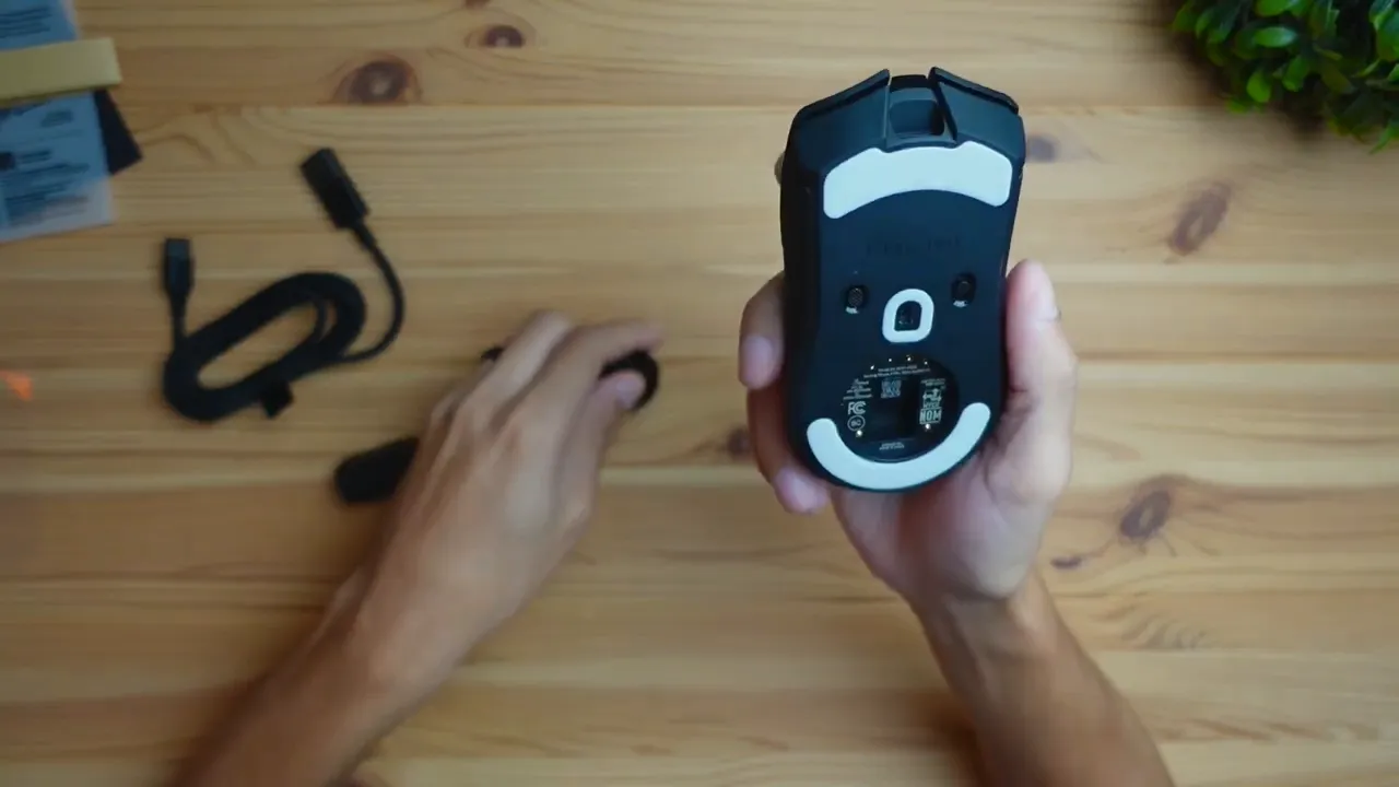 Razer Cobra Pro mouse underside showing sensor, glide pads and USB dongle compartment