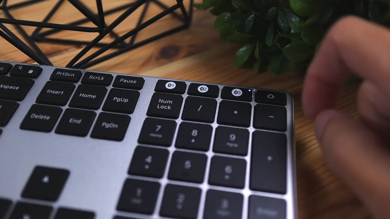 Hand pressing Jelly Comb keyboard Bluetooth device switch button with LED indicator lit