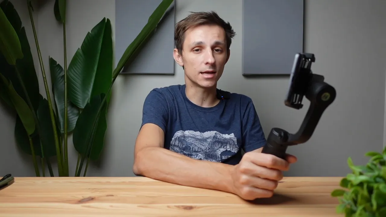 Presenter holding a FeiyuTech Vlog Pocket gimbal at a desk, ready to recommend it