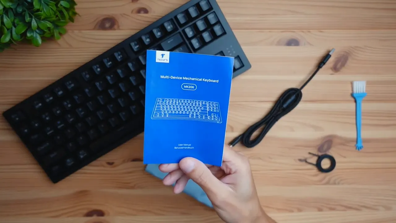 Unboxing contents laid out: keyboard, USB-A to USB-C cable, keycap puller, cleaning brush, cloth, manual