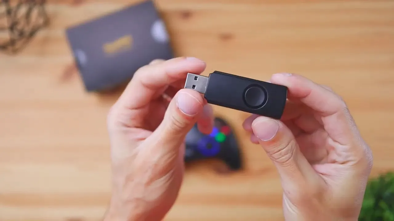 Two hands holding the EasySMX wireless USB dongle, connector visible and in focus