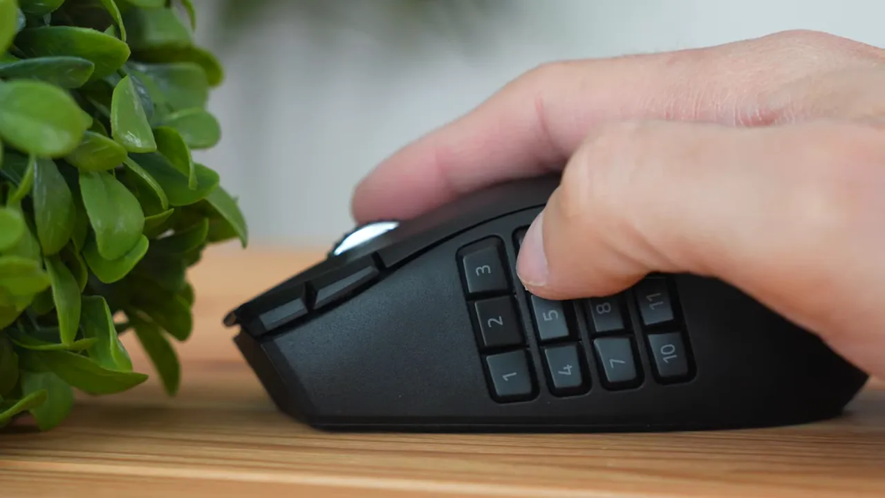 User thumb pressing a numbered button on the Razer Naga V2 12-button side grid to show reach and spacing.