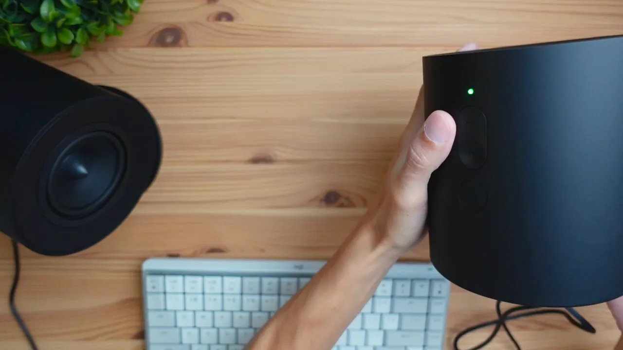 Power button lit green indicating speakers are on