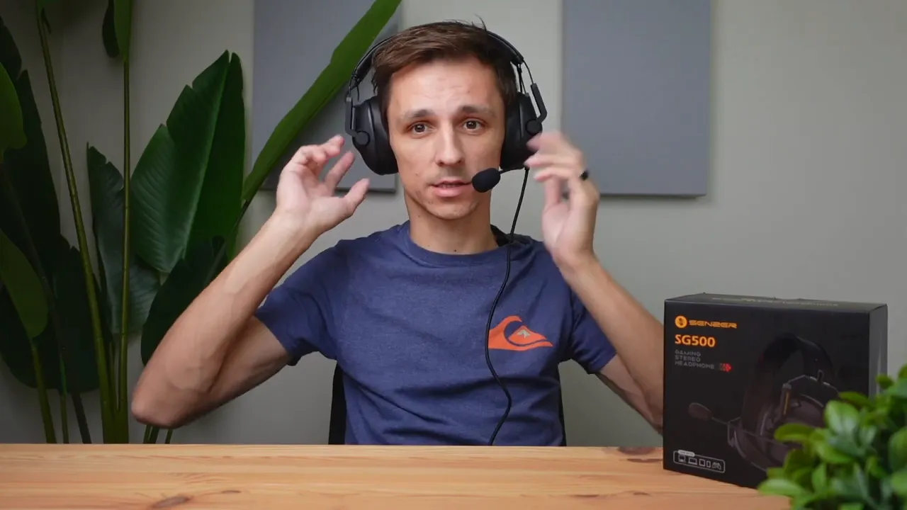 Reviewer wearing the Senzer SG500 gaming headset with microphone boom extended, adjusting the earcups to show fit