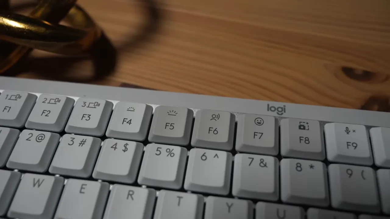 Close-up of Logitech MX Mechanical MINI top-left keys showing device switch icons above F1–F3 and part of the function row.