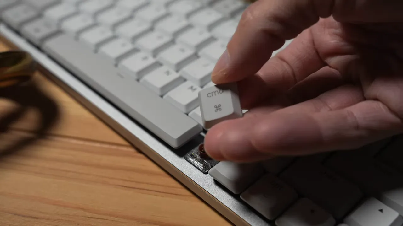 Close-up of a removed Cmd keycap and the exposed tactile (brown-style) switch on the MX Mechanical MINI