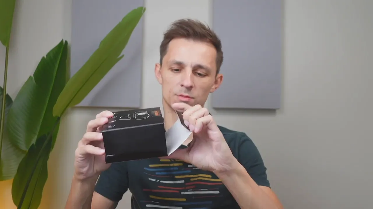 Person opening the NUROUM V32AFL webcam box in a home office setting