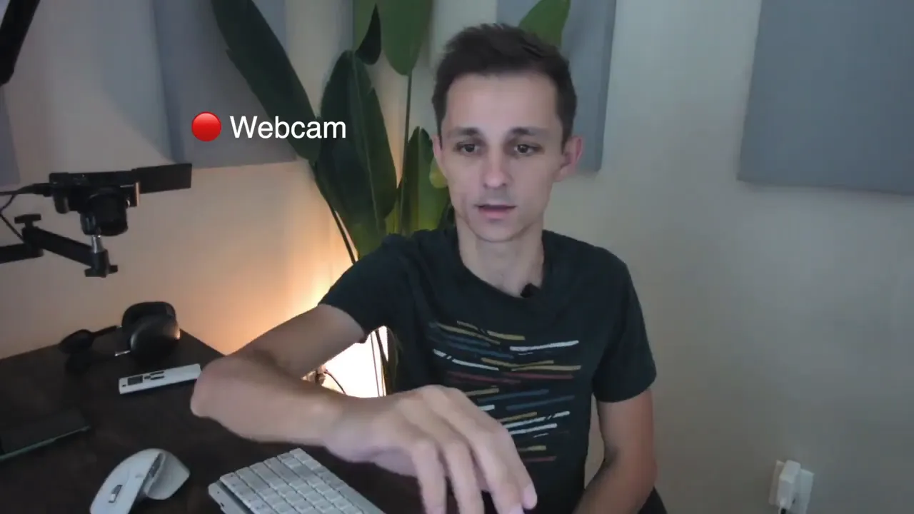 Clear webcam view of a person at a desk with warm background lighting showing ring-light fill in low-light conditions