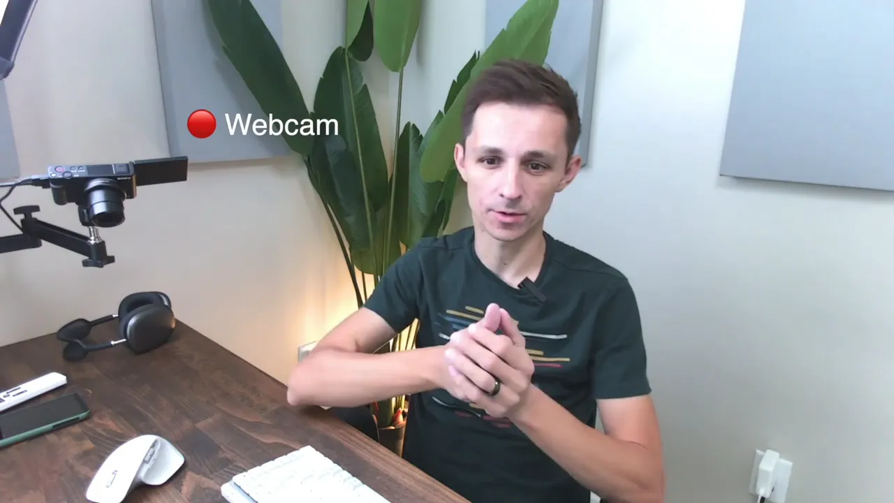 Workspace view with presenter wearing a lavalier mic, webcam and desk visible